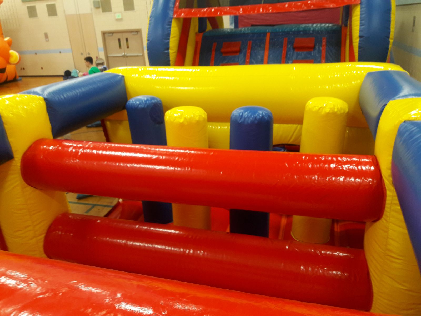 Inflatable logs and pop-up obstacles inside inflatable rental by Froggy Hops